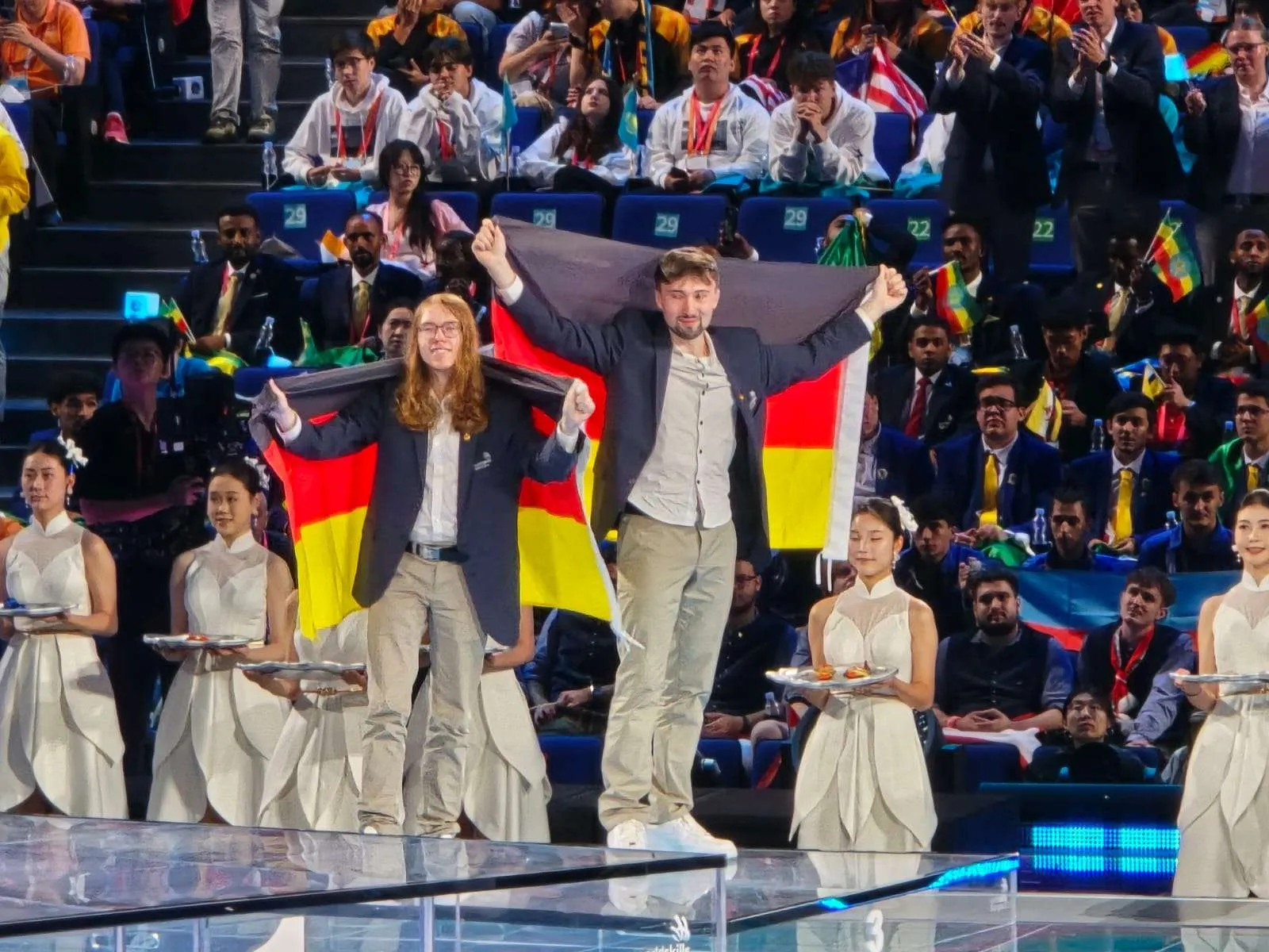 Die beiden deutschen Teilnehmer feiern bei der Siegerehrung mit Deutschlandflaggen.