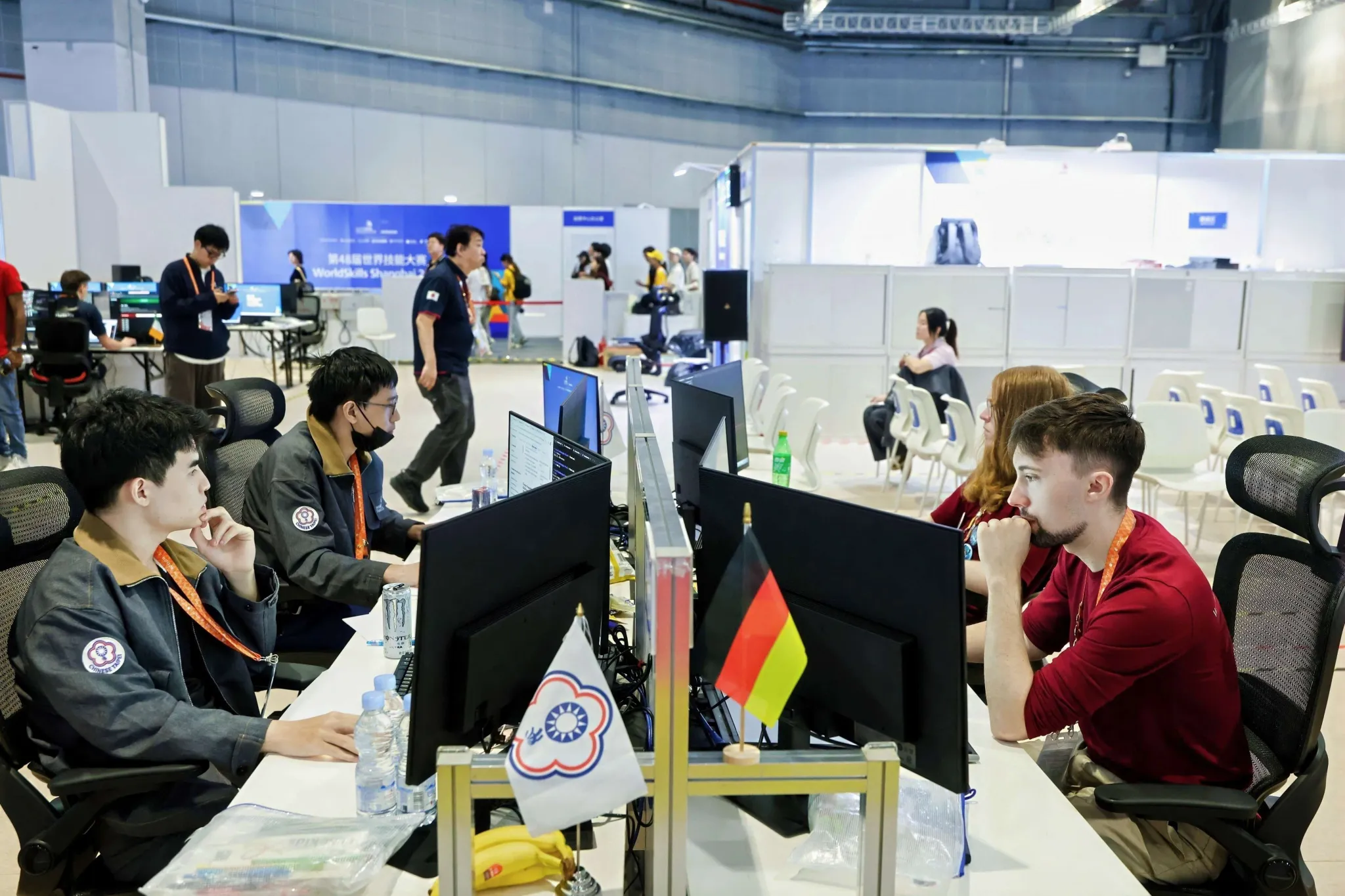 Teilnehmer aus Deutschland und Chinese Taipei arbeiten an ihren Computern im Cyber-Security-Wettbewerb.